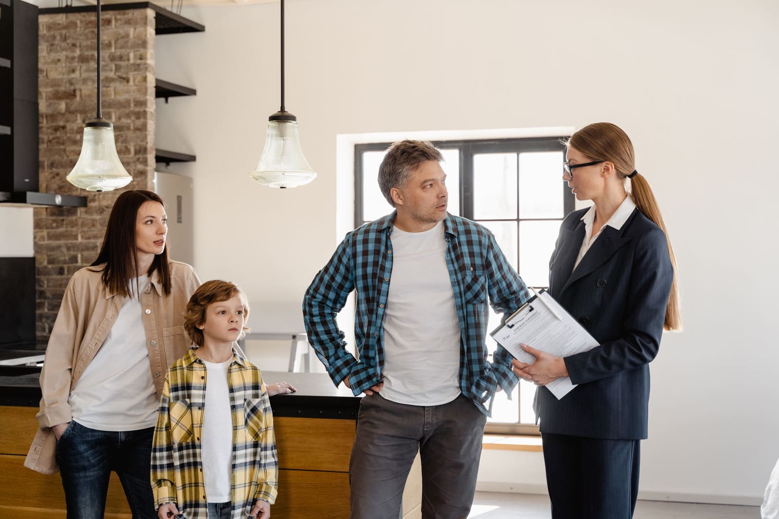 A family talking with a professional in their kitchen.