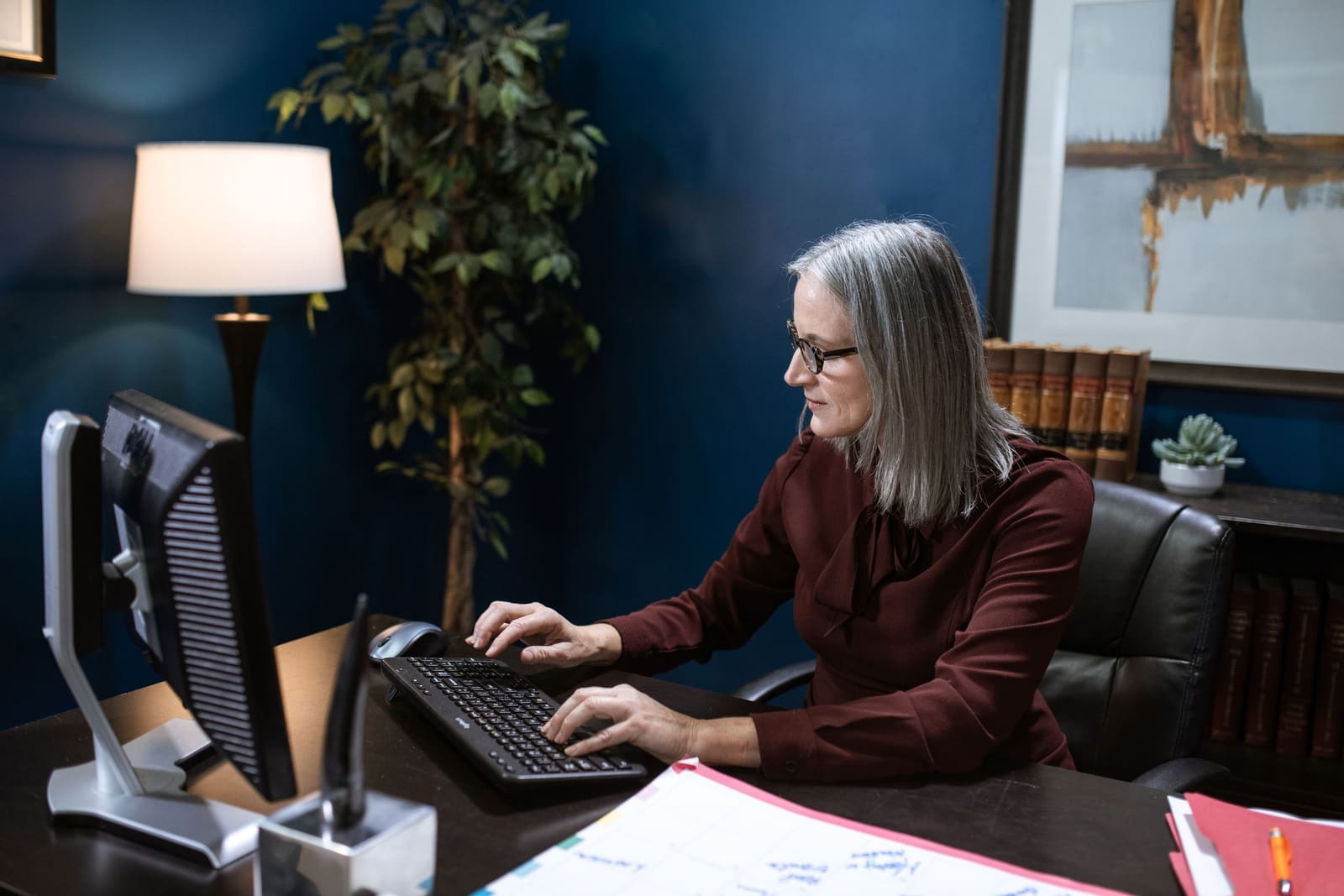 A woman at a desk, working at a computer.